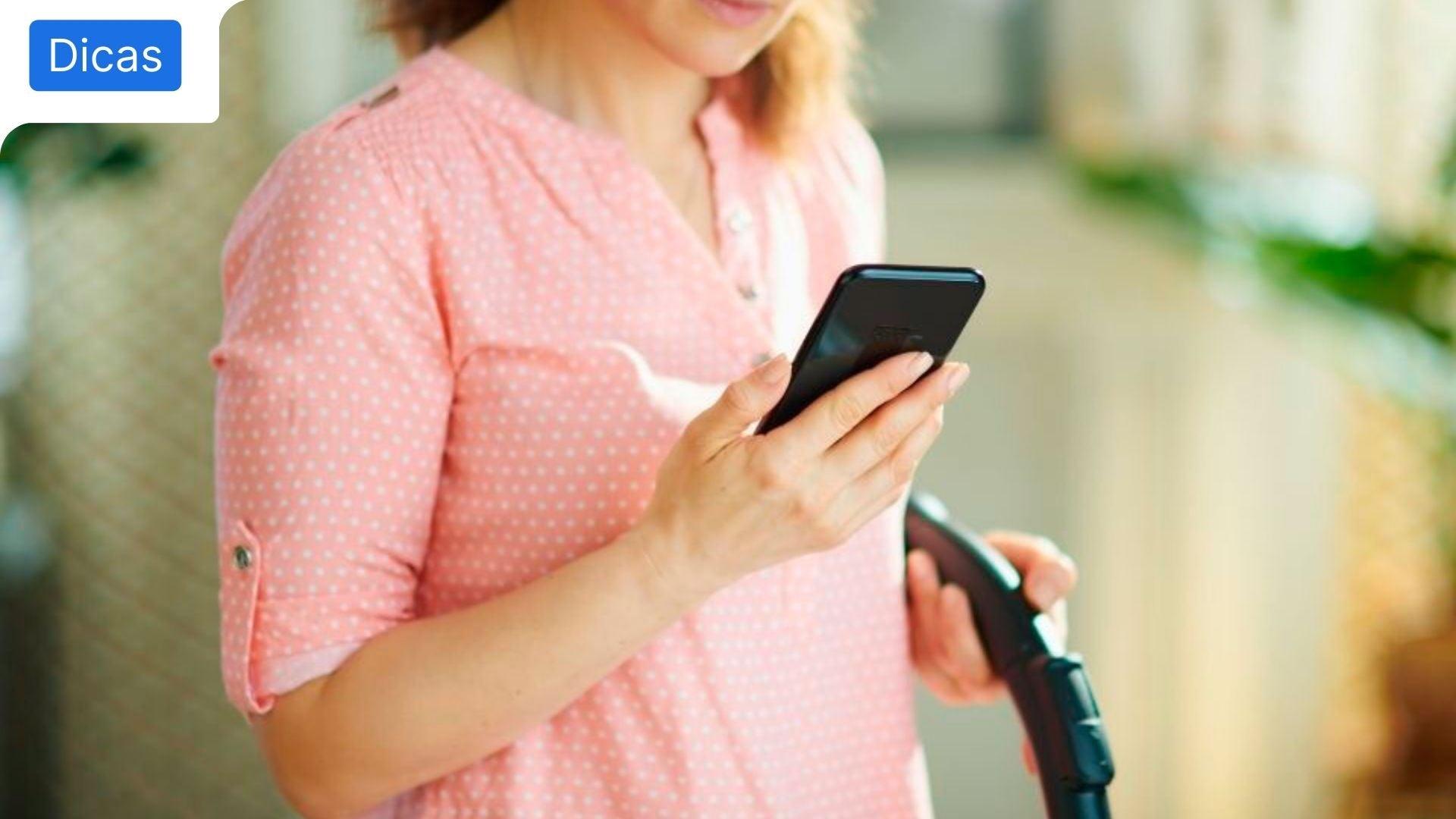 Rapariga a agarrar no telemóvel e a limpar, para retratar o tema de apps de limpeza