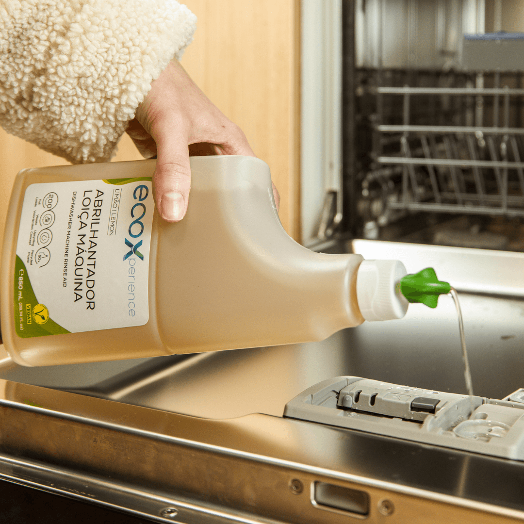 Mão a colocar abrilhantador para máquina de lavar loiça EcoX 850mL no compartimento da máquina