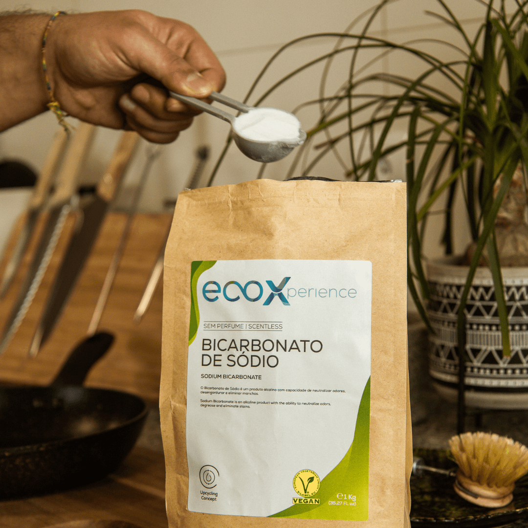 Embalagem de bicarbonato de sódio EcoX 1Kg ao lado de uma mão a segurar num doseador com o produto