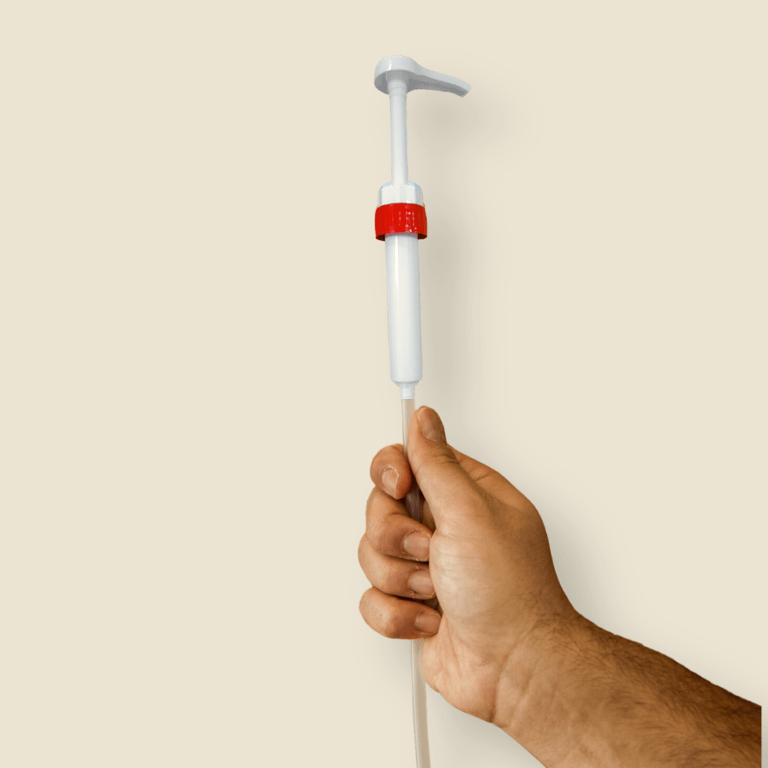 Mão a segurar na bomba doseadora EcoX para os detergentes em garrafões de 5L