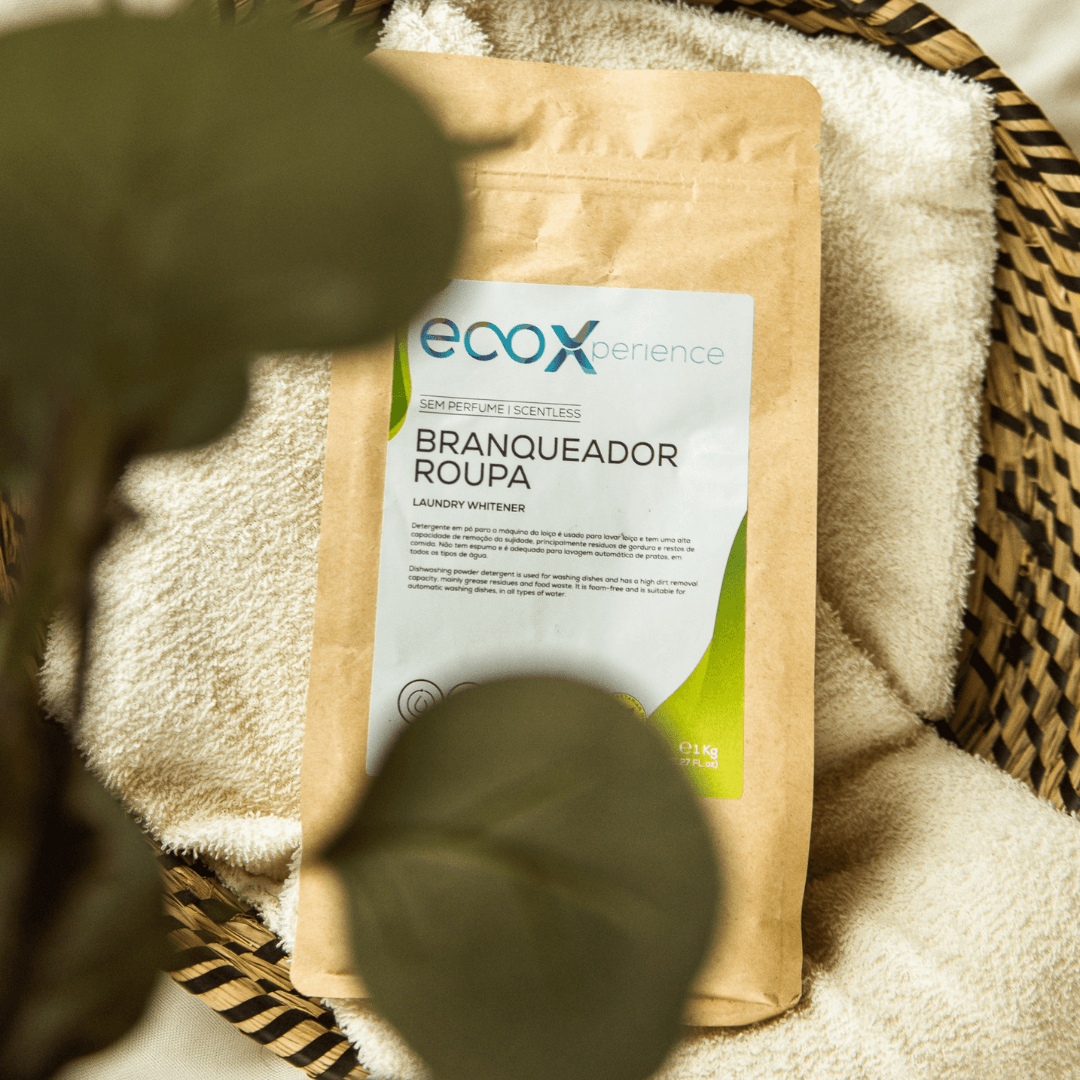 Embalagem de branqueador de roupa EcoX 1kg em cima de uma toalha, num cesto