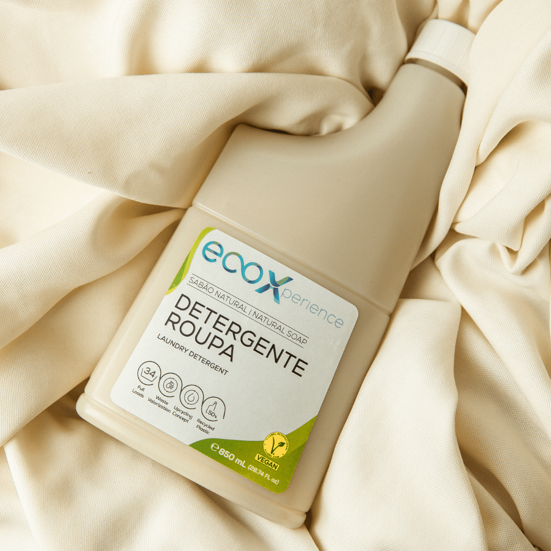 Embalagem de detergente roupa sabão natural EcoX 850mL em cima de uma peça de roupa