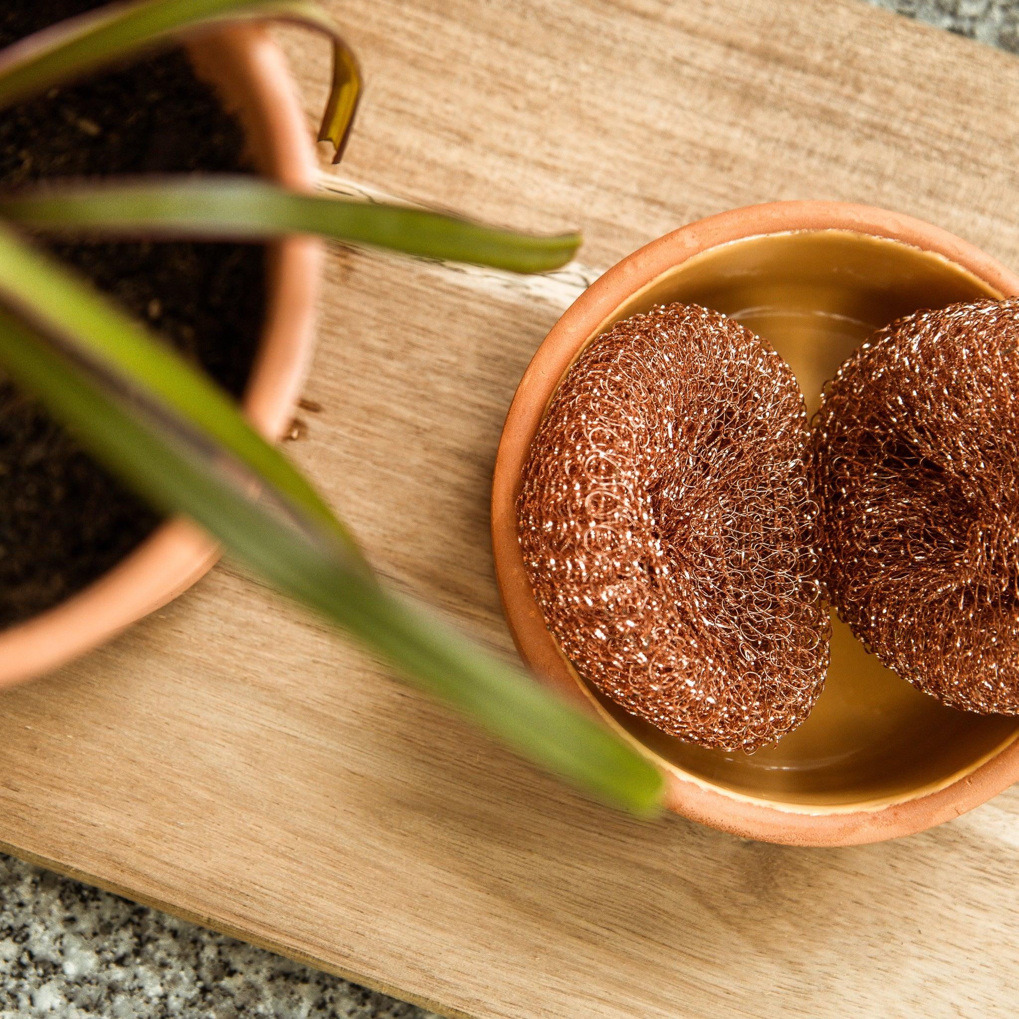 Esfregão da loiça em cima de uma tábua de madeira