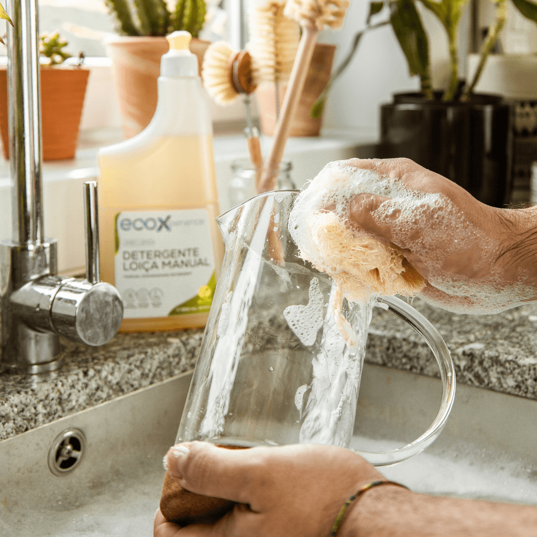 Mão a lavar peça de loiça com a lufa