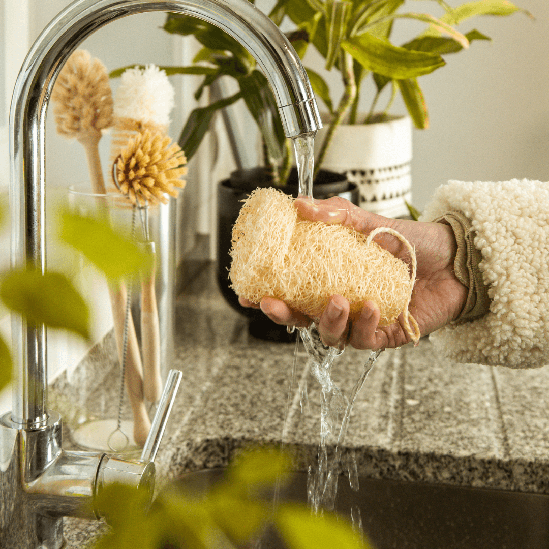 Mão a molhar a lufa com água