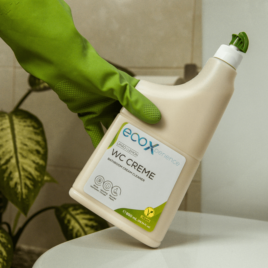 Mão com luvas de latex ecológico a segurar no wc creme EcoX