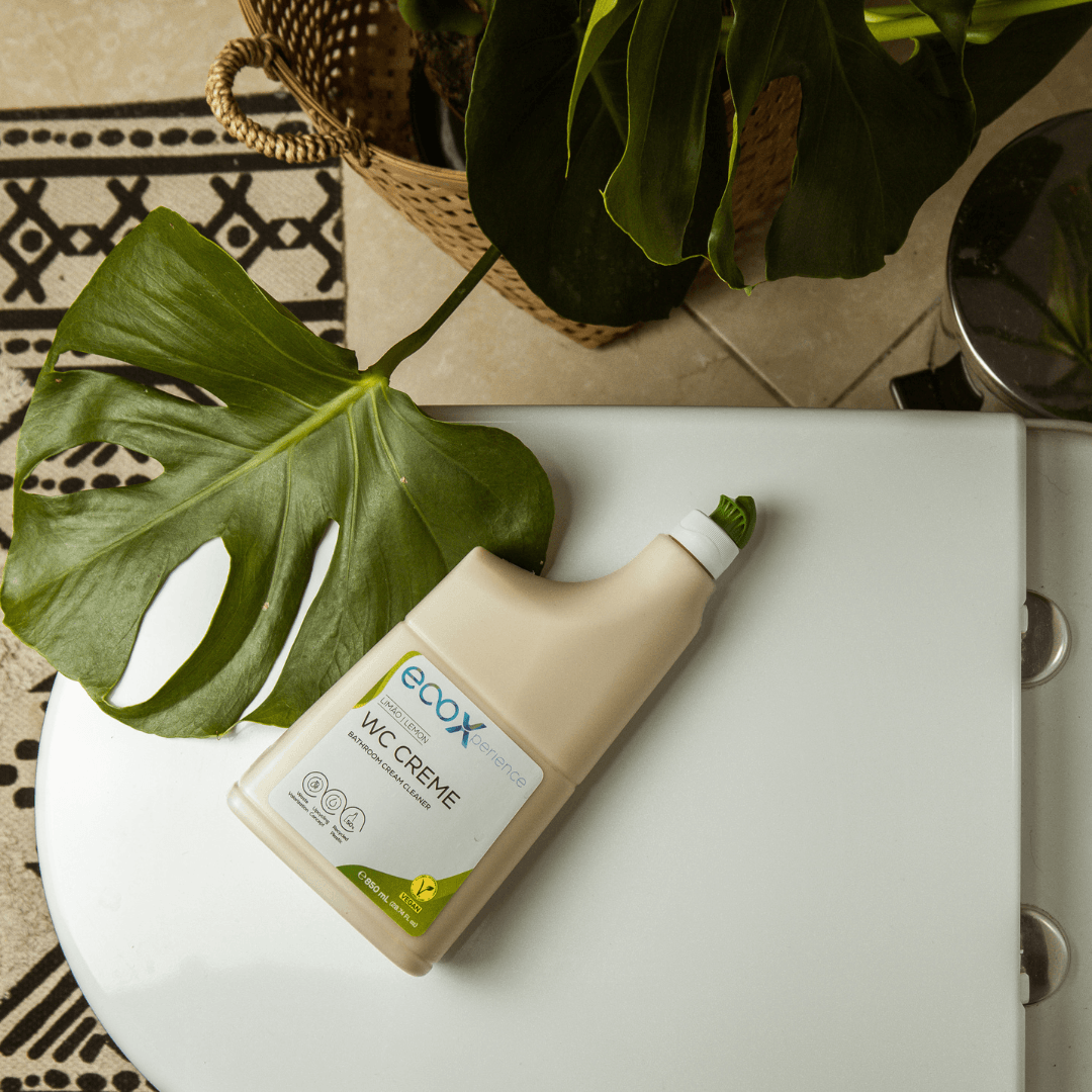 Embalagem de WC creme EcoX 850mL em cima do tampo da sanita com uma planta ao lado
