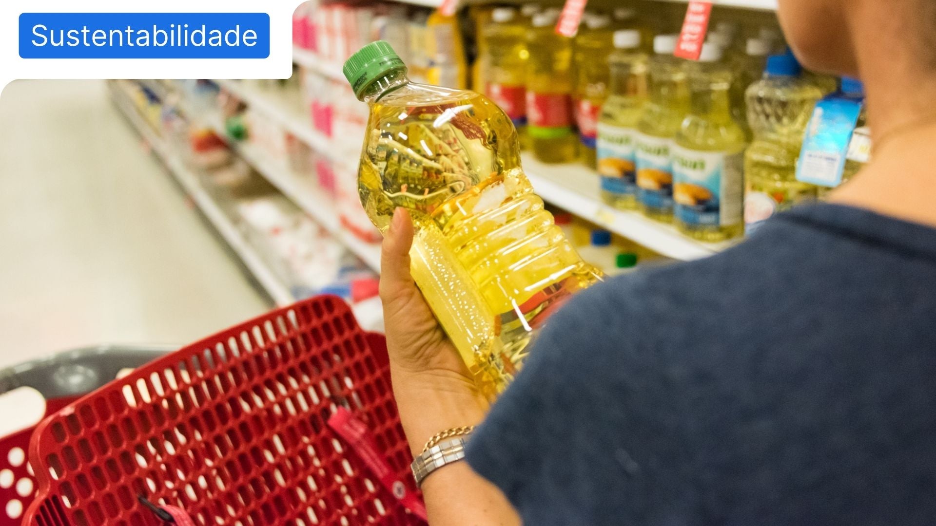 Pessoa a agarrar numa garrafa de óleo usado, no corredor de supermercado dos óleos alimentares usados