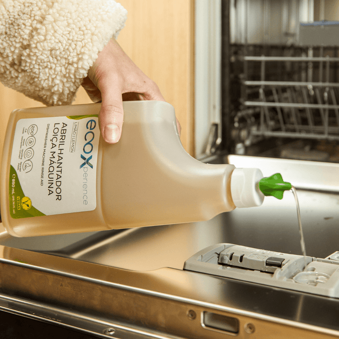 Mão a colocar abrilhantador para máquina de lavar loiça EcoX 850mL no compartimento da máquina