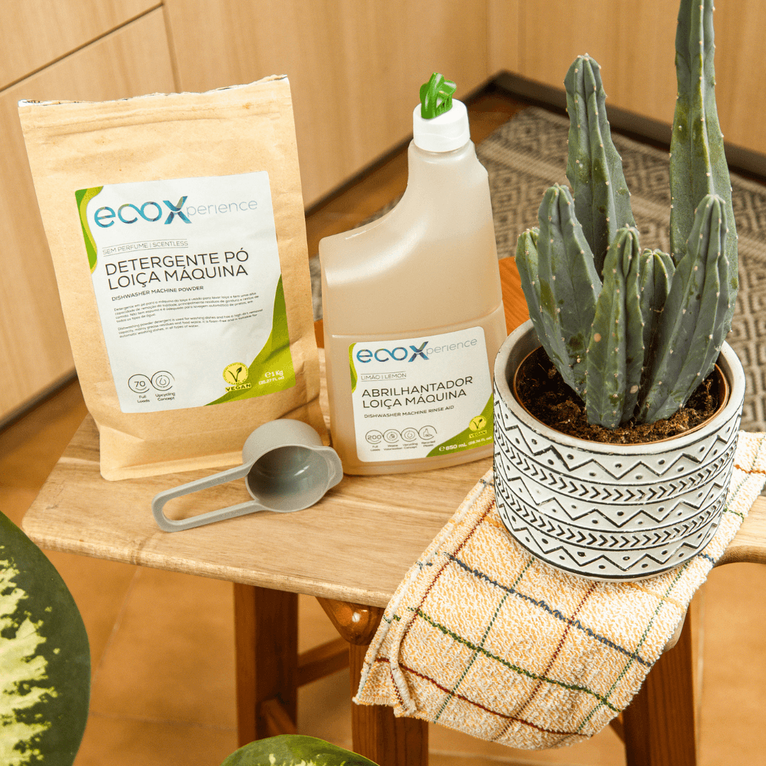 Abrilhantador para máquina de lavar loiça ao lado do detergente loiça máquina e de uma planta