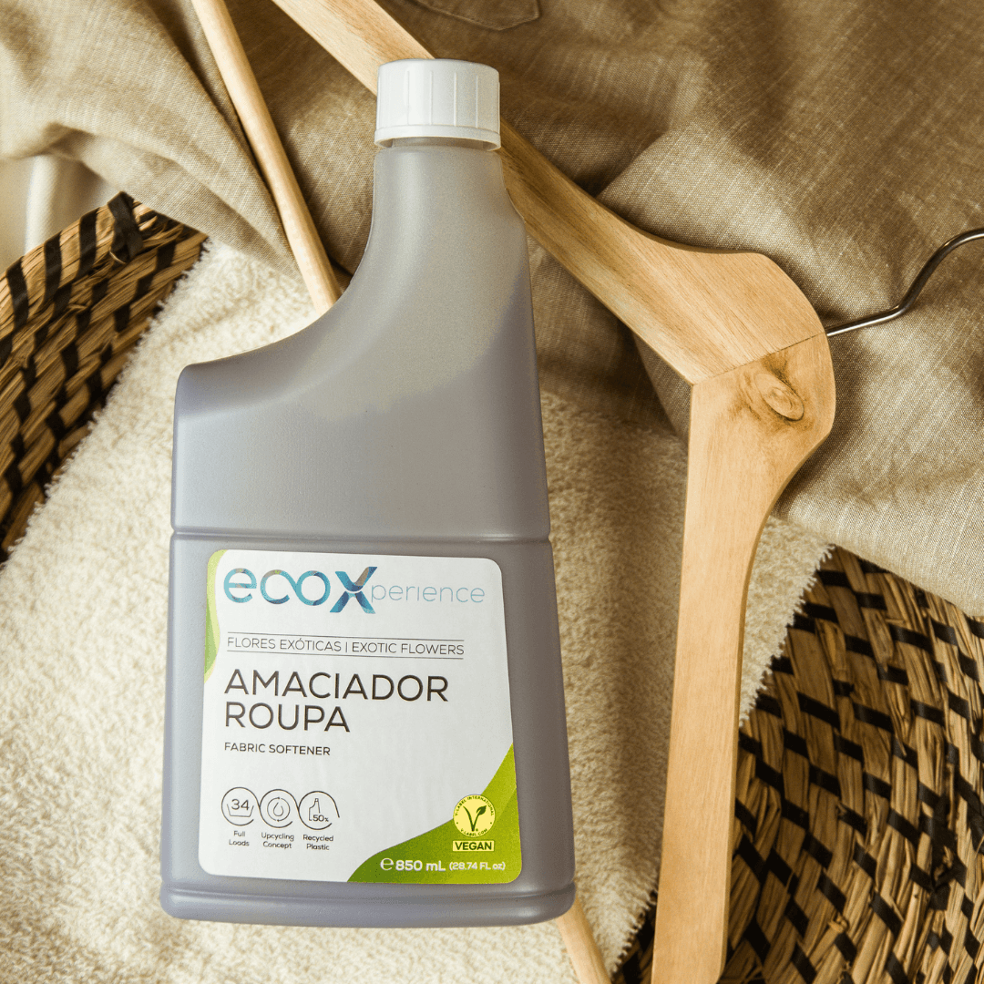 Embalagem amaciador da roupa flores exóticas EcoX 850mL em cima de uma toalha e peça de roupa, com uma cruzeta ao lado