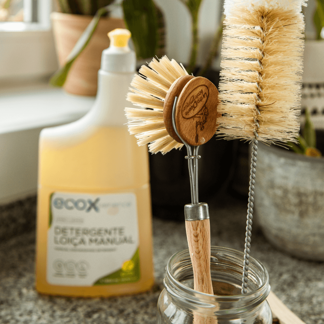 Escova de madeira para a loiça ao lado do escovilhão e do detergente loiça EcoX 850mL