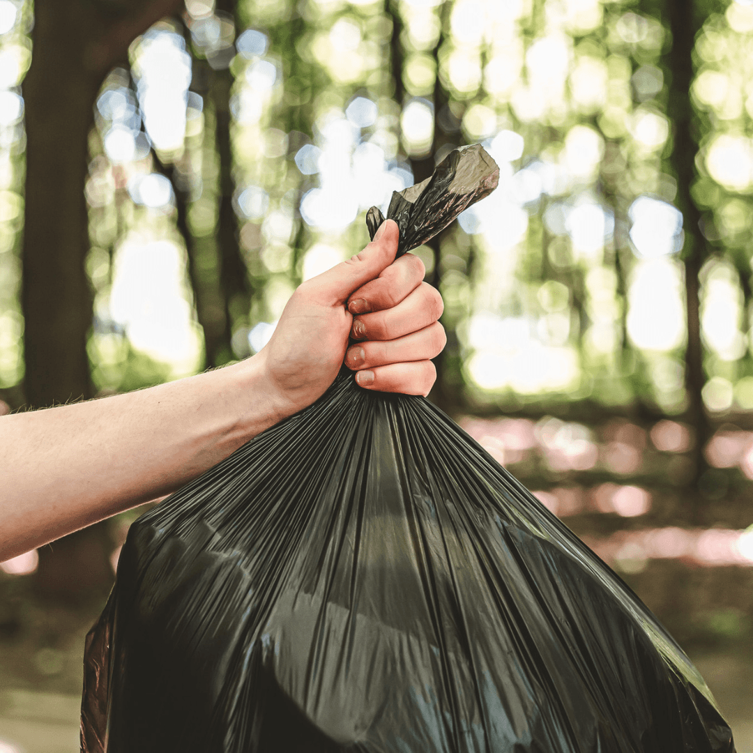 Pessoa a agarrar num saco de lixo ecológico