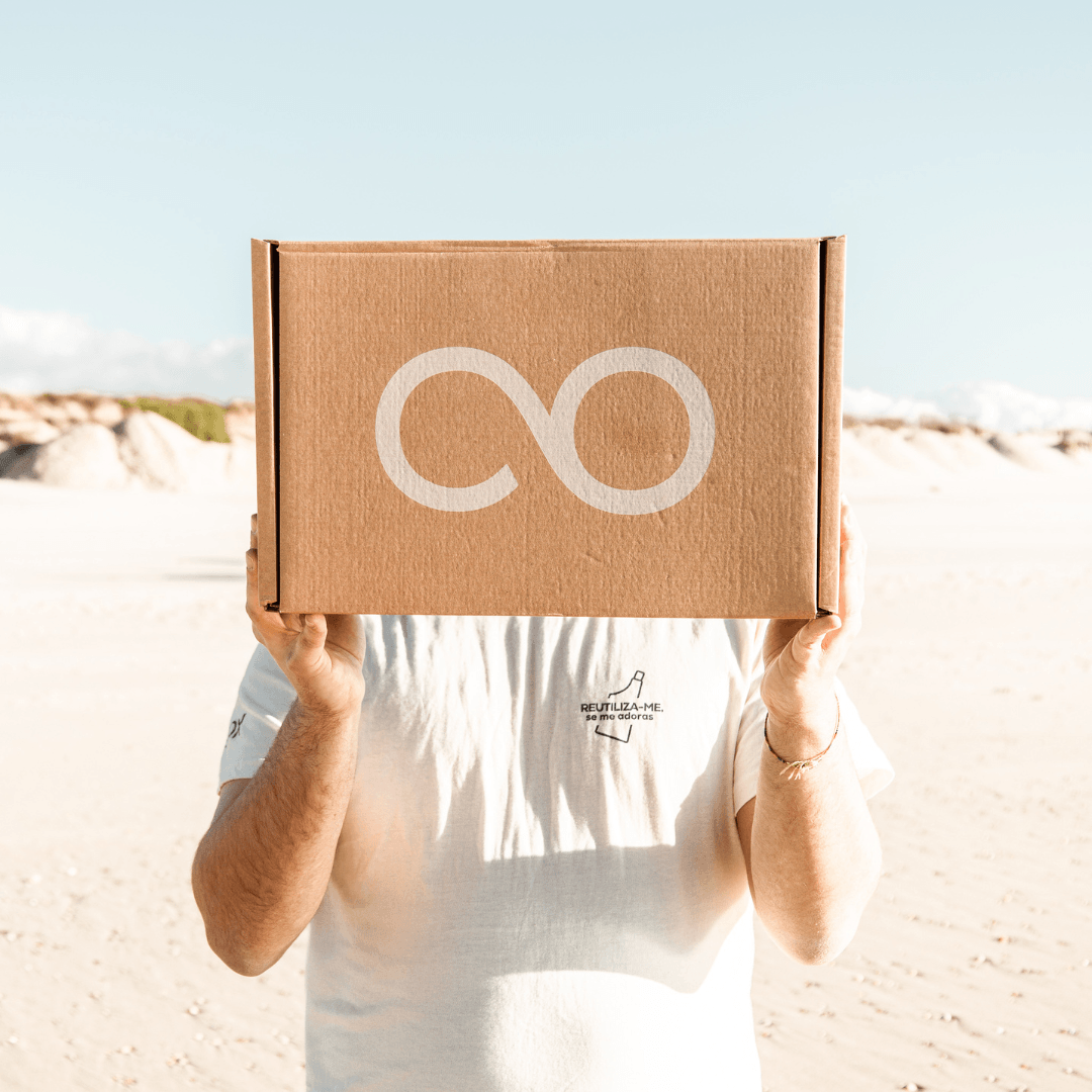Rapaz com a T-shirt "Reutiliza-me, se me adoras" a segurar uma caixa com o símbolo infinito da EcoX